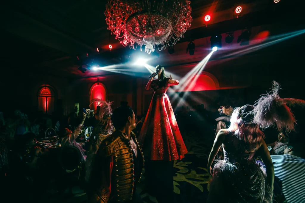 Performer in a red gown on stage during AIA Group's masquerade gala event photography in Dubai